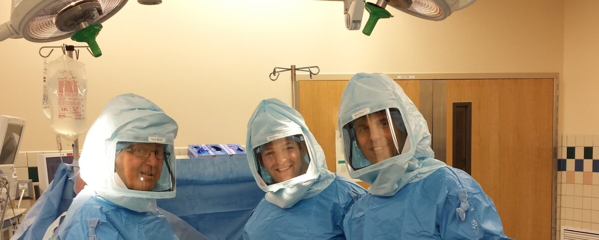 Dr. Matthew Wichman with his father and brother, all orthopedic surgeons, gowned together in the operating room